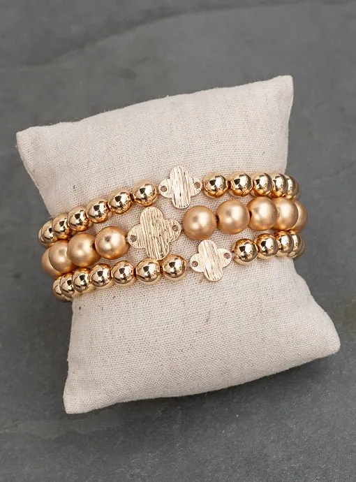 Matte And Shiny Gold Three Piece Bracelet Set With Clover