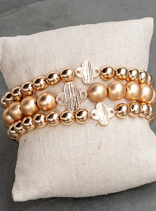 Matte And Shiny Gold Three Piece Bracelet Set With Clover