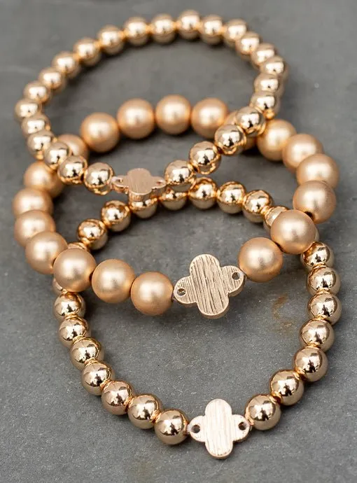 Matte And Shiny Gold Three Piece Bracelet Set With Clover